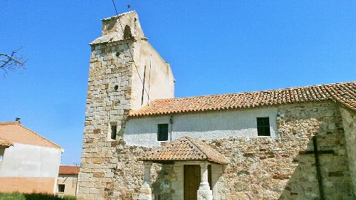Pfarrkirche Unserer Lieben Frau der Himmelfahrt in Valcabado mit Steinturm und rotem Dach.