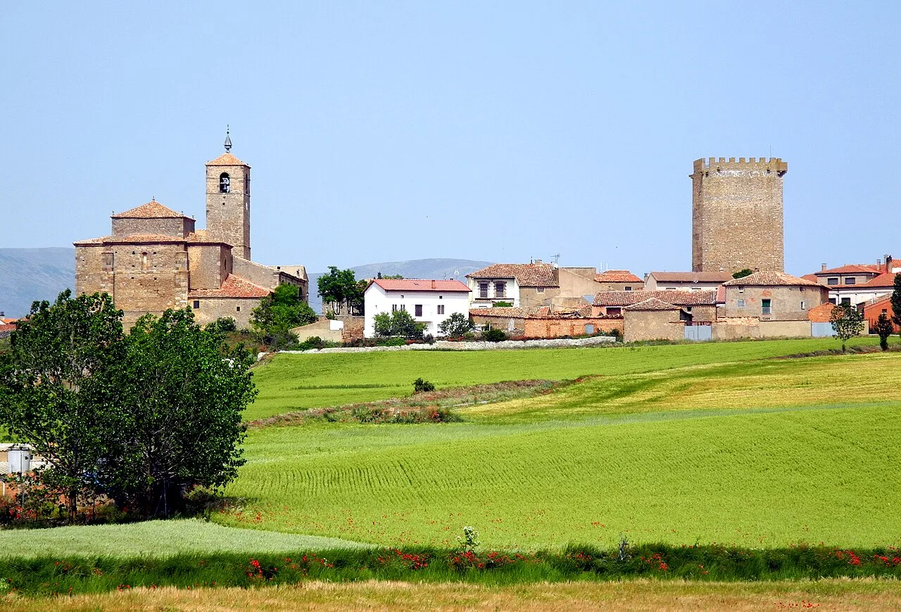 Campos verdes y edificios con torres en Noviercas, Soria.