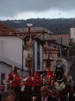 Procesión con figuras religiosas y velas en una calle de Guía de Isora.