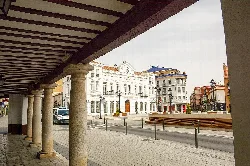 Columns and roof in the foreground with view of the square and historic buildings.