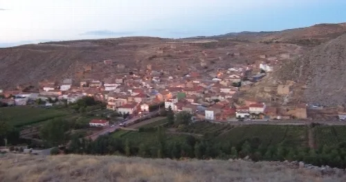 View of Cimballa from the castle at sunset, with houses and hills.
