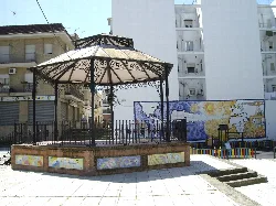 Ein Kiosk auf dem Platz mit Wandmalereien im Hintergrund.