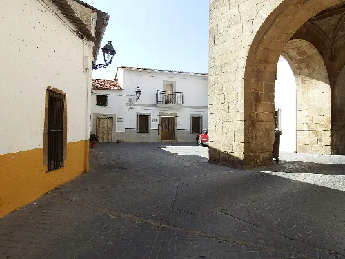 Straße in Arroyomolinos mit Steingang und weißen Häusern.