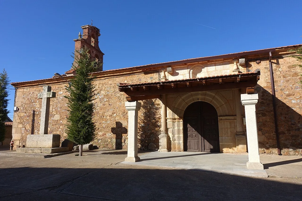 Stone church facade with columns and wooden door in Sepulcro-Hilario.