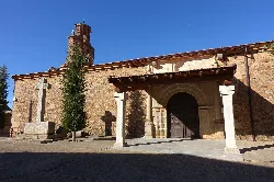 Stone church facade with columns and wooden door in Sepulcro-Hilario.