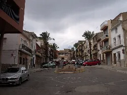 View of the Plaza de España with palm trees and buildings in Godelleta.