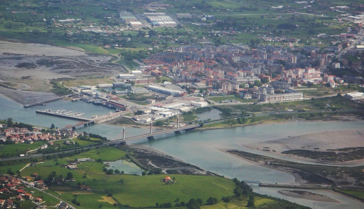 Vista aérea de Colindres con río, puerto y ciudad.