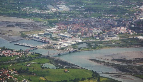 Luftaufnahme von Colindres mit Fluss, Hafen und Stadt.
