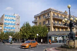 Plaza con árboles, parada de autobús y edificios en Santo Domingo de la Calzada.