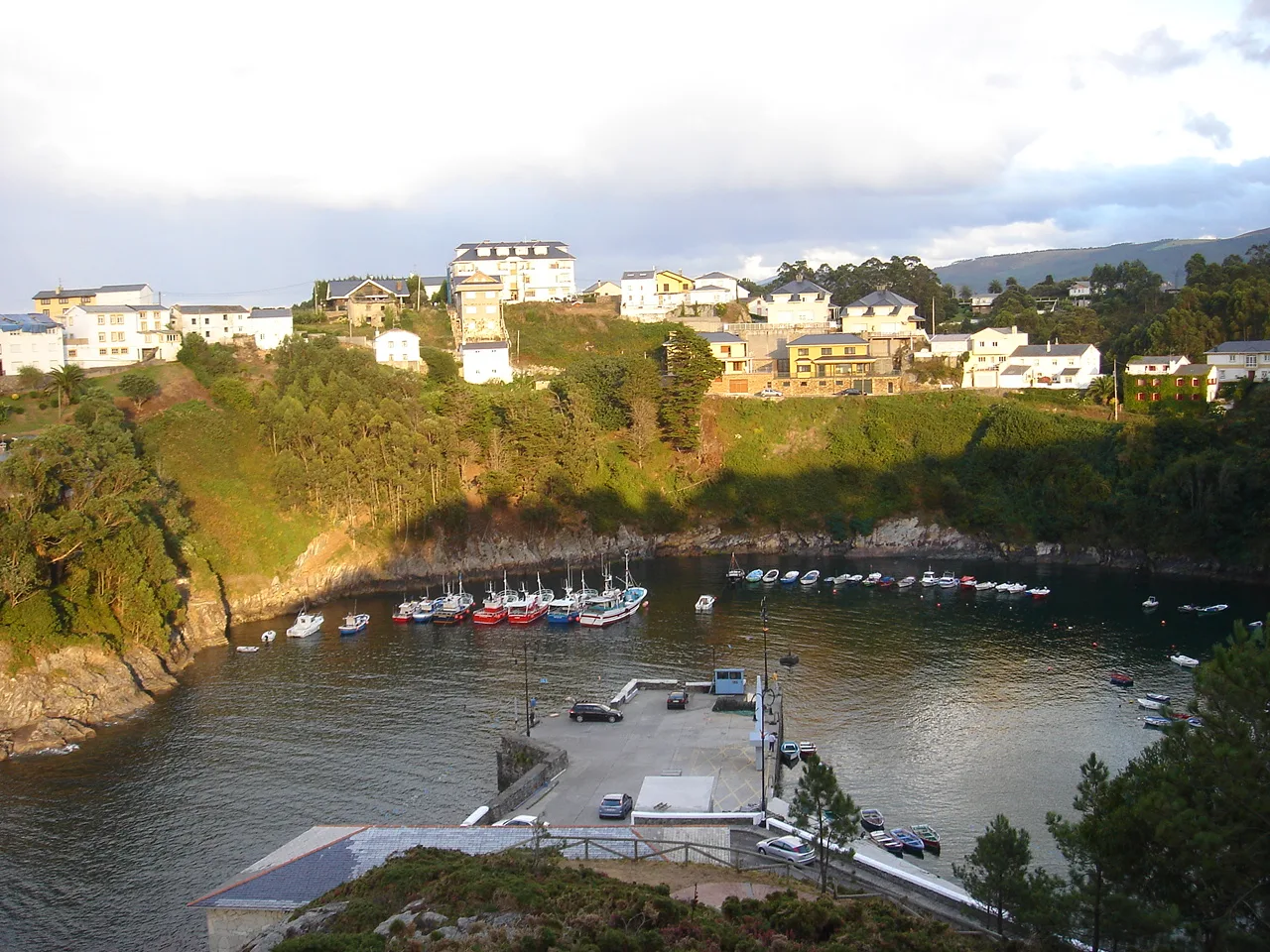 Puerto con casas blancas y barcos en El Franco, Asturias.