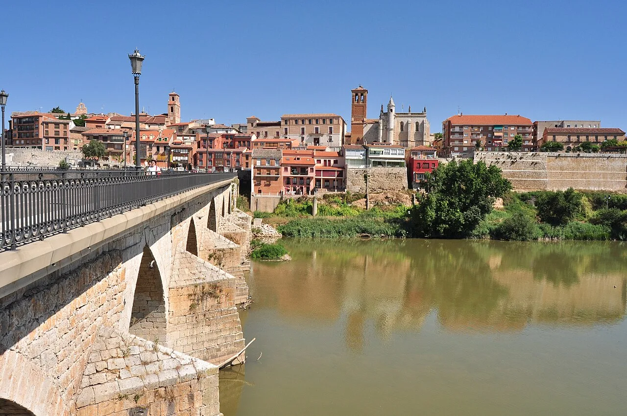 Río con edificios históricos y una iglesia en Tordesillas.