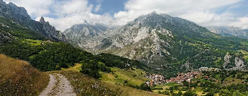 Panorama de montañas y un pueblo en un valle en Cabrales, Asturias