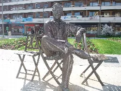 Estatua de Luis Mariano sentado en un banco en los jardines de Irún.