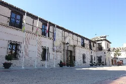 Fachada del palacio con banderas y farola en la plaza.