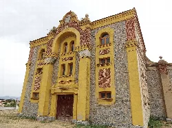 Facade of a building with yellow details and stone in Piedrahíta.