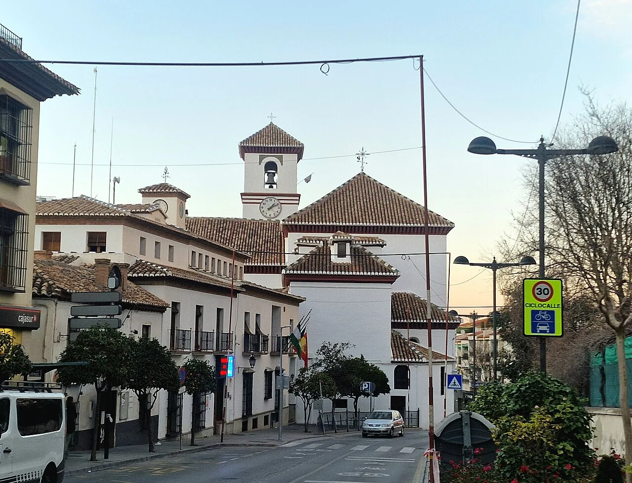 Church with bell tower and red roof in La Zubia.