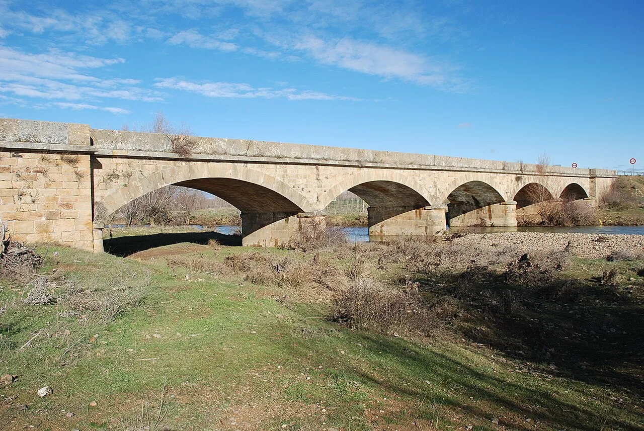 Stone bridge with multiple arches over the Valdavia River in Villaeles de Valdavia.