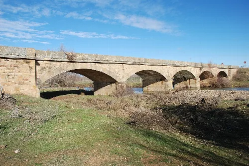 Stone bridge with multiple arches over the Valdavia River in Villaeles de Valdavia.