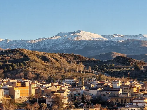Vista de la localidad de Beas de Granada, en la provincia de Granada (España), con Sierra Nevada al fondo. Imagen tomada desde la carretera GR-3107.