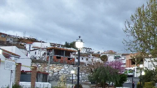 Weiße Häuser und bewölkter Himmel in Dehesas de Guadix.