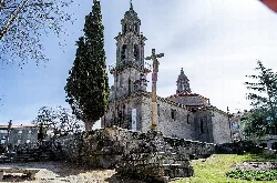 San Benito Church and crucifix in Allariz, with tower and cross.