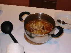 Knoblauchsuppe in Edelstahltopf auf weißem Tisch