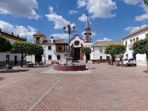 Plaza de Santa Ana con árboles, bancos y fuente en Cañada Rosal.