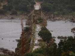 Puente de Ajuda con estructura antigua y vegetación, visto desde Elvas.