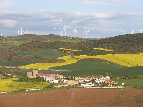Paisaje con molinos de viento en las colinas y pueblo en primer plano.