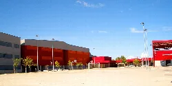 Edificio del IES Villanueva de Gállego con estructura moderna y áreas de entrada rojas.