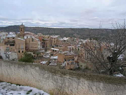 Vista de casas y una iglesia en Letur, Albacete, con colinas al fondo.