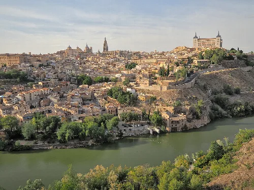 Vista panorámica de Toledo con río y ciudad histórica.