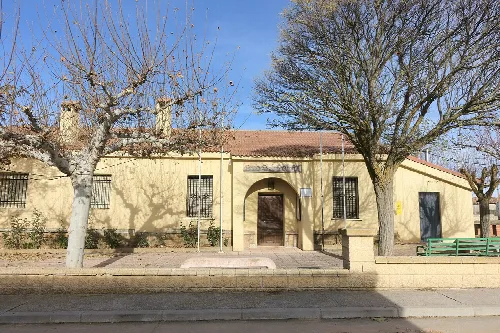 Town hall with leafless trees and a simple facade.