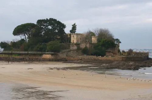 Castillo de Santa Cruz en Oleiros, Galicia, junto a la playa y rodeado de árboles.