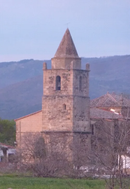 Steinerne Kirchturm mit Esel im Vordergrund bei Sonnenuntergang.