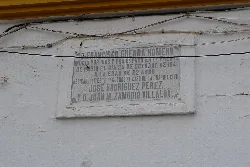 Placa en la pared con texto en español.
