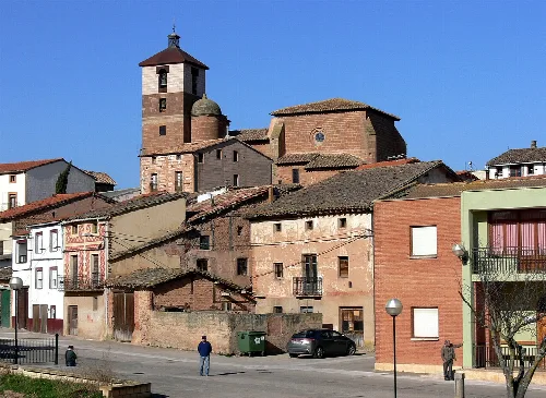 Casas y iglesia en Cañas, La Rioja, bajo un cielo azul.