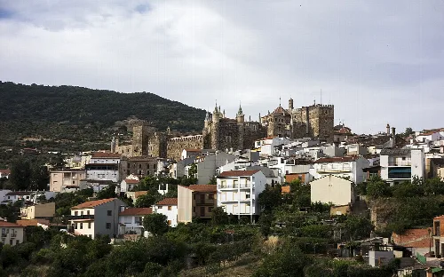 Blick auf eine Hügelstadt mit Burg und weißen Häusern