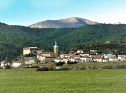 Vista panorámica de Erro con iglesia y convento en un entorno montañoso.