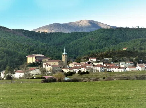 Vista panorámica de Erro con iglesia y convento en un entorno montañoso.