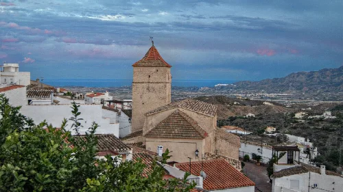 Torre de la iglesia y tejados en Bédar con Mojácar en las montañas.