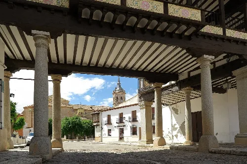 Blick auf den Plaza Mayor von Tembleque mit Säulen und weißen Gebäuden.