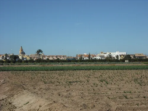 Landwirtschaftliche Landschaft mit Stadt und blauem Himmel.