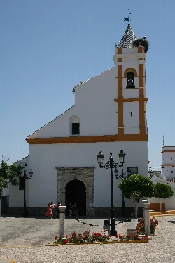 Iglesia blanca con torre y campanario en Almadén de la Plata.