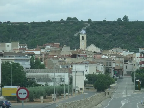 Urban landscape of Vall d'Alba with church and houses on a cloudy day.