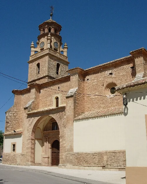 Iglesia de La Gineta con torre y reloj, construida en piedra.