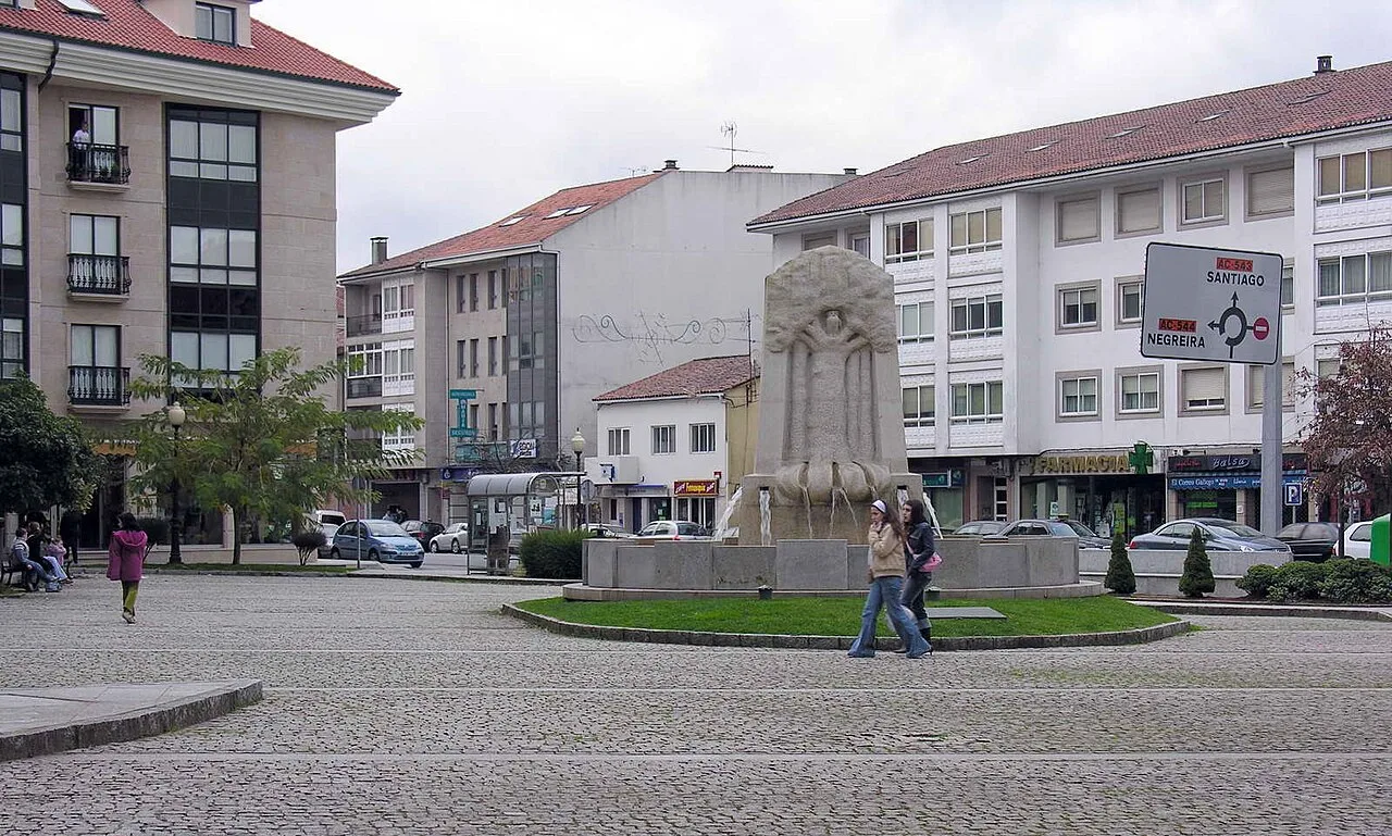 Platz mit Brunnen und Wohnhäusern in Bertamiráns, Ames.