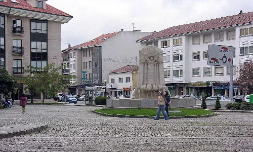 Platz mit Brunnen und Wohnhäusern in Bertamiráns, Ames.