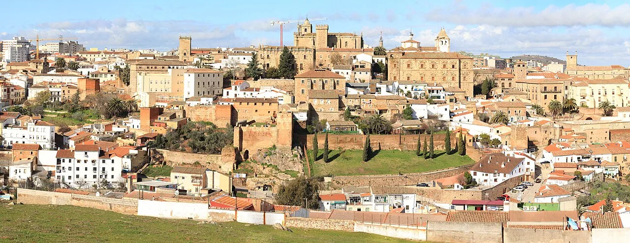 Panoramic view of Cáceres with historic buildings and walls on a sunny day.