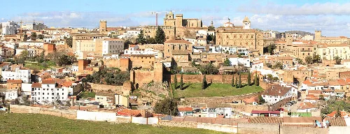 Panoramic view of Cáceres with historic buildings and walls on a sunny day.